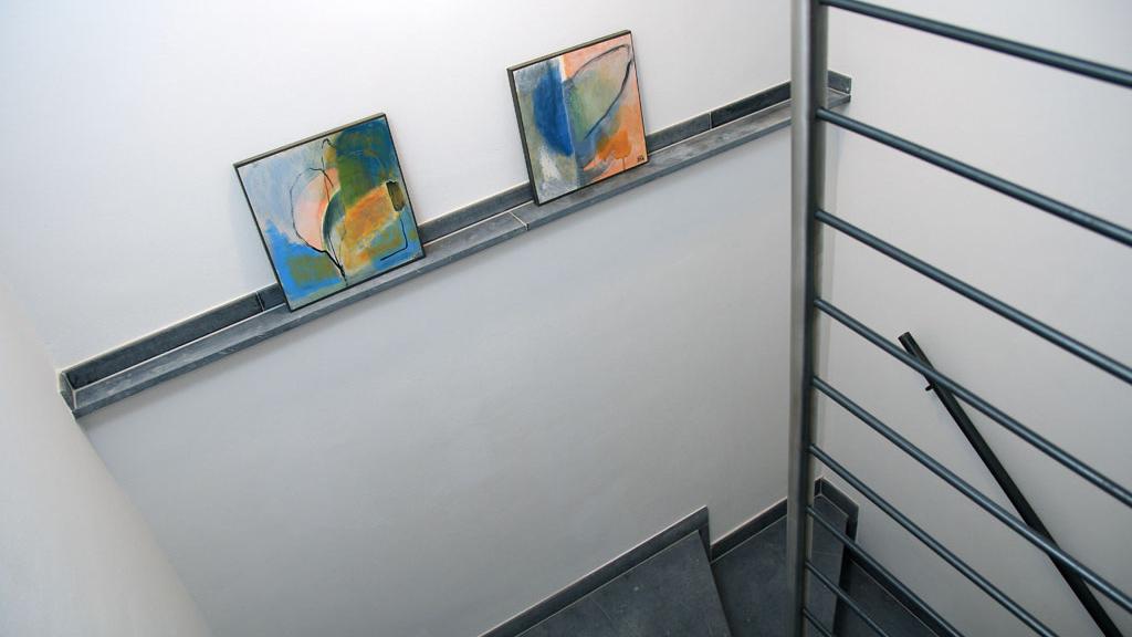 Bilder u.a. von Künstlerinnen, die einige Jahre ihr Atelier hier hatten, schmücken das Treppenhaus.